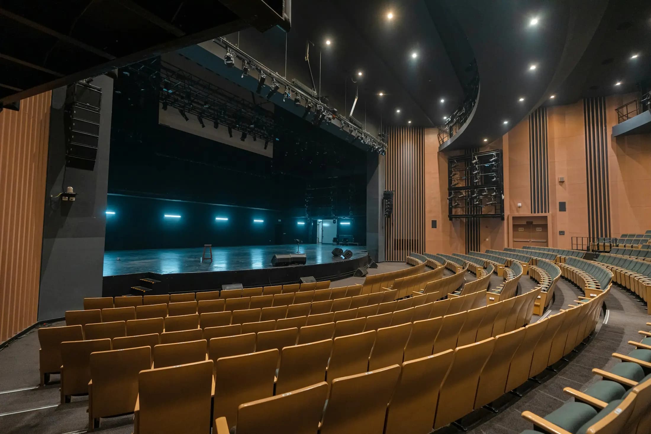 Un auditorium aux fauteuils dorés face à une scène éclairée