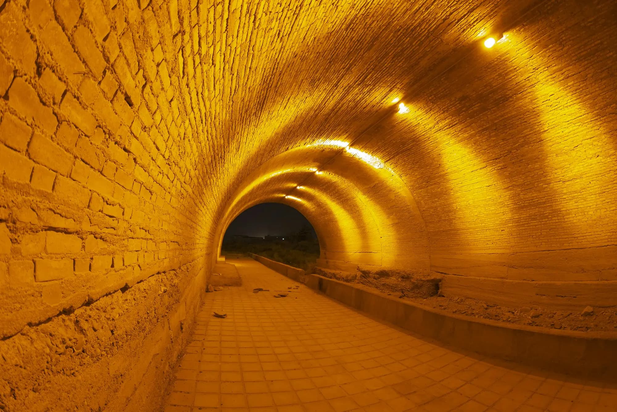 A brick tunnel washed in orange light